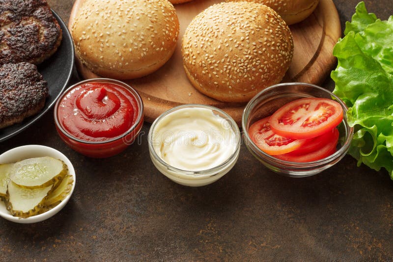 Świezi składniki dla hamburgerów: babeczki, cutlet, kumberlandy, warzywa i sałatka, zdjęcia stock Świezi składniki dla hamburgerów: babeczki, cutlet, kumberlandy, warzywa i sałatka, zdjęcia stock