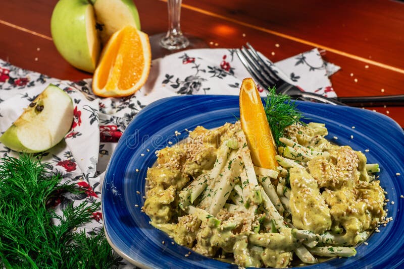 Świeża sałatka z kurczakiem, pomarańczą, jabłkiem i sosem curry Podawane białym winem i serem na niebieskiej płytce Drewniany obraz royalty free Świeża sałatka z kurczakiem, pomarańczą, jabłkiem i sosem curry Podawane białym winem i serem na niebieskiej płytce Drewniany obraz royalty free