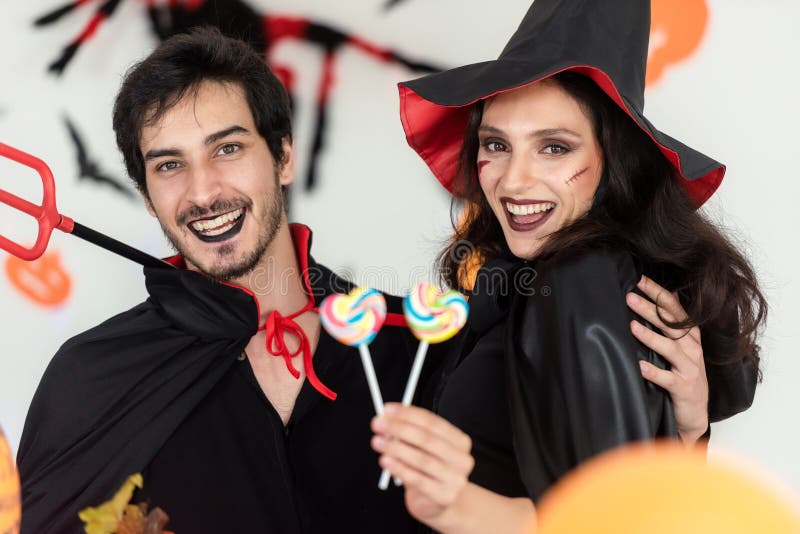 Party Halloween holiday.  Young couple party and celebrate with Halloween pumpkin and cocktails with having fun and happy at home. Party Halloween holiday.  Young couple party and celebrate with Halloween pumpkin and cocktails with having fun and happy at home