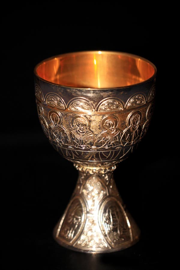 Photo of a silver cup with gold inside edge against dark background. Holy Grail were the cup from which Jesus drank at the Last Supper. Also the goblet or cup which Christ's blood is collected at his crucifixion. Photo of a silver cup with gold inside edge against dark background. Holy Grail were the cup from which Jesus drank at the Last Supper. Also the goblet or cup which Christ's blood is collected at his crucifixion.