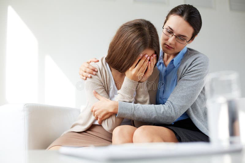 Lonely girl weeping while psychologist embracing her. Lonely girl weeping while psychologist embracing her