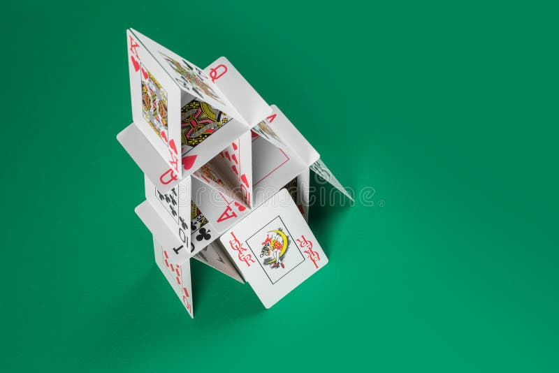 żartowniś na tle domu kart na zielonym stole gry zdjęcie stock