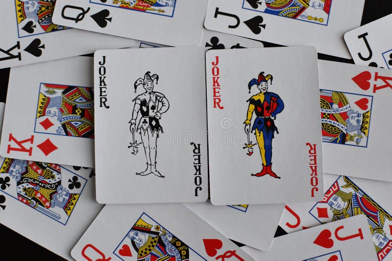 żartowniś z karty na tle rozrzuconych kart zdjęcia stock