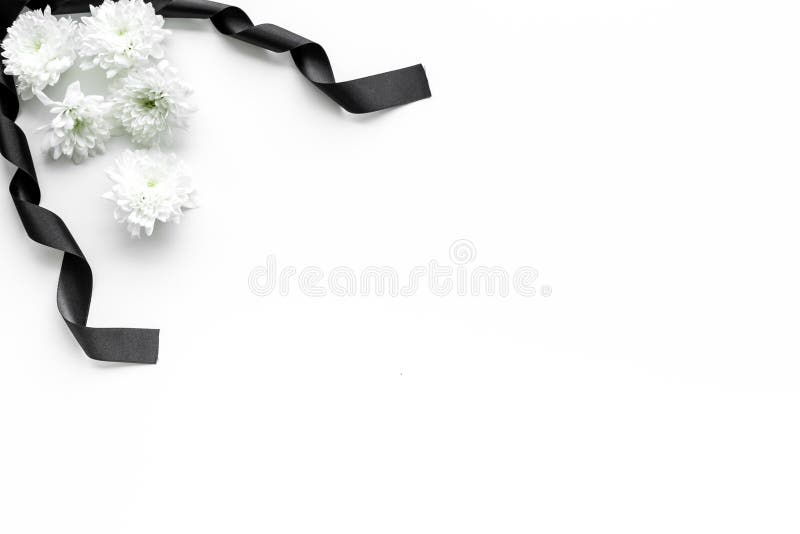 Żałobni symbole Biały kwiat blisko czarnego faborku na białej tło odgórnego widoku kopii przestrzeni fotografia royalty free Żałobni symbole Biały kwiat blisko czarnego faborku na białej tło odgórnego widoku kopii przestrzeni fotografia royalty free