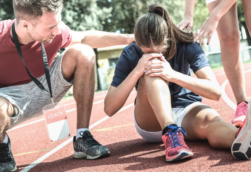 Żeńska atleta dostaje raniący podczas sportowego bieg szkolenia - samiec powozowa bierze opieka na sporta uczniu po fizycznego wy