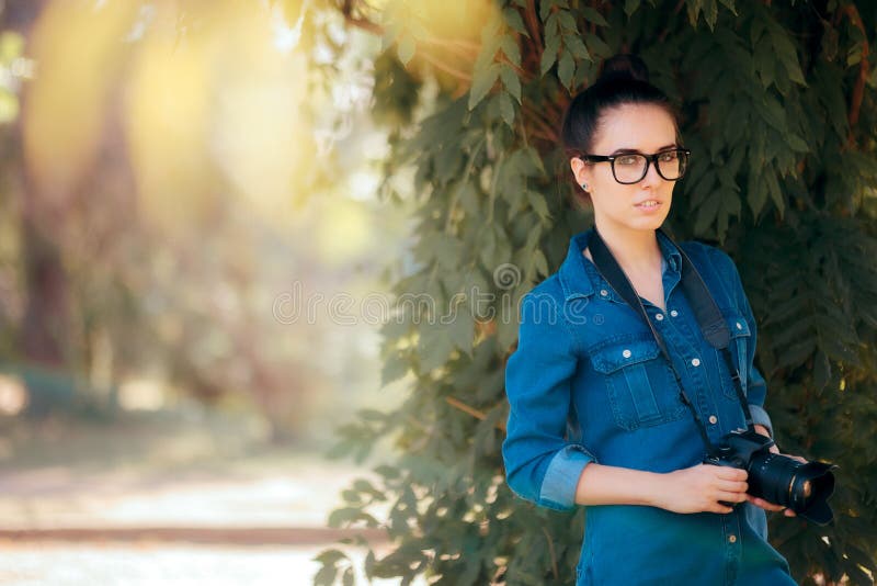 Żeński fotograf z DSLR kamerą w parku fotografia royalty free Żeński fotograf z DSLR kamerą w parku fotografia royalty free