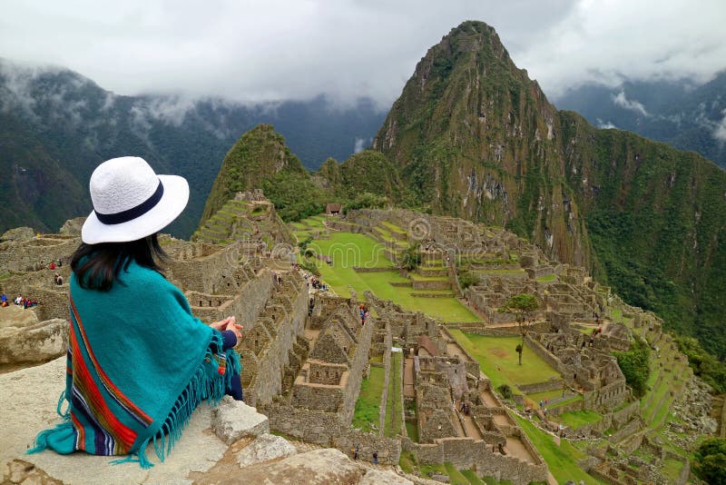 Żeński podróżnika obsiadanie na falezie Patrzeje inka ruiny Mach Picchu, Peru obrazy stock Żeński podróżnika obsiadanie na falezie Patrzeje inka ruiny Mach Picchu, Peru obrazy stock
