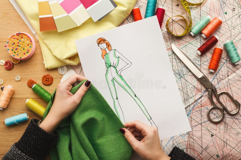 Żeński projektant mody pracuje z tkaniny próbką i patroszoną ilustracją obrazy stock