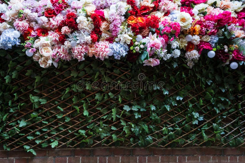 Żywy układ różnych sztucznych kwiatów na ścianie ceglanej fotografia stock