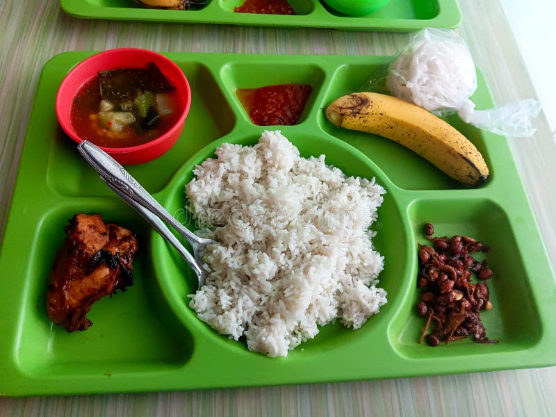 Żywy, zielony zasobnik z posiłkiem indonezyjskim : Rice Chicken Soup Banana and Sambal obraz royalty free