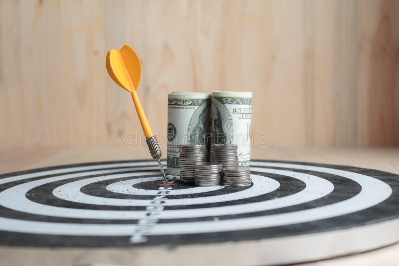 Żółta strzałki strzała uderza centrum cel menniczy metafory oszczędzania lub marketingu pieniądze pojęcie dartboard i pieniądze fotografia stock Żółta strzałki strzała uderza centrum cel menniczy metafory oszczędzania lub marketingu pieniądze pojęcie dartboard i pieniądze fotografia stock