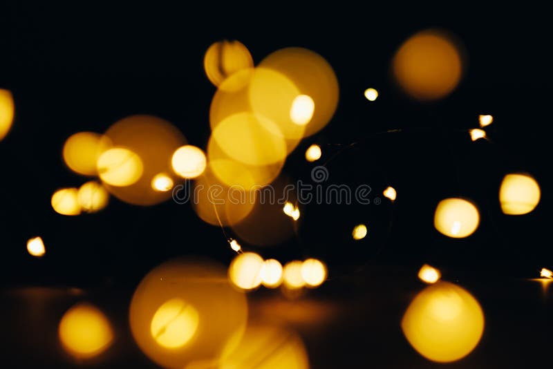 Yellow lens flare. Defocused circle lights. Night party gleam effect. Abstract black background. Yellow lens flare. Defocused circle lights. Night party gleam effect. Abstract black background.