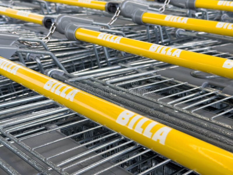 Żółte uchwyty koszyka z logo billa w ustawieniach sklepu spożywczego zdjęcia stock