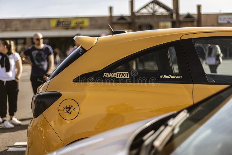 Żółty opel corsa sportowy fałszywy naklejka taksówkowa zaparkowany w pobliżu centrum handlowego zdjęcie royalty free