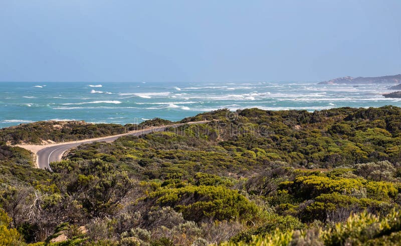 Șoseaua de coastă curbează apele turcoaz și stâncile stâncoase din Australia de Sud cu un indicator de avertizare în prim-plan royalty free stock photo