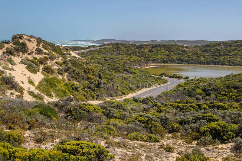 Șoseaua de coastă curbează apele turcoaz și stâncile stâncoase din Australia de Sud cu un indicator de avertizare în prim-plan stock photos