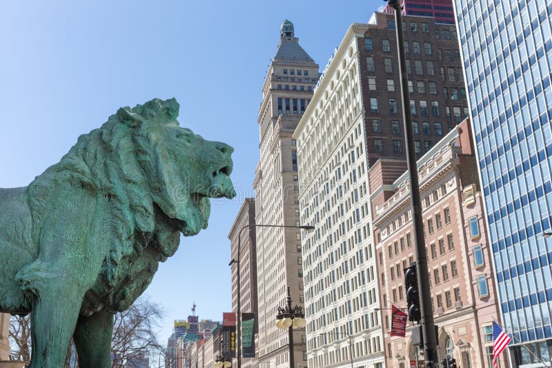 Chicago, USA - April 7, 2018: Bronze lion statue standing guard at the Art Institute of Chicago. There are two lion statues at the museum's Michigan Avenue entrance. They are famous Chicago landmarks and date to 1894. Chicago, USA - April 7, 2018: Bronze lion statue standing guard at the Art Institute of Chicago. There are two lion statues at the museum's Michigan Avenue entrance. They are famous Chicago landmarks and date to 1894.