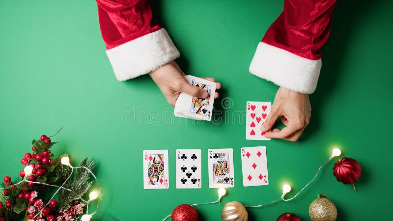 Santa Claus playing solitaire with cards . Santa Claus playing solitaire with cards .