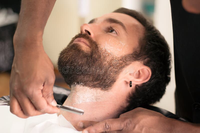 Άνδρας ξυρίζει το μούσι στο κουρείο στοκ εικόνες με δικαίωμα ελεύθερης χρήσης Άνδρας ξυρίζει το μούσι στο κουρείο στοκ εικόνες με δικαίωμα ελεύθερης χρήσης