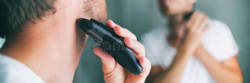 άνδρας ξύρισμα γενειάδα με ηλεκτρικό τρίψιμο. πανόραμα για την ομορφιά. νέος τρόπος ζωής στοκ εικόνες