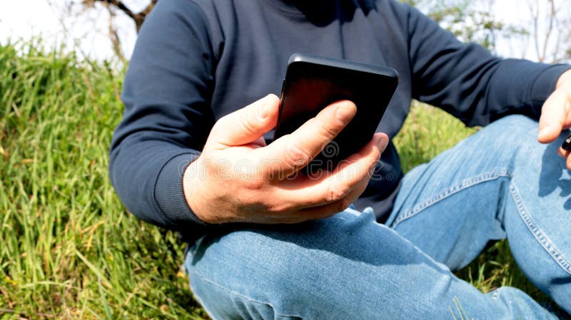 Άνδρας που χρησιμοποιεί smartphone σε εξωτερικό χώρο στοκ εικόνα με δικαίωμα ελεύθερης χρήσης