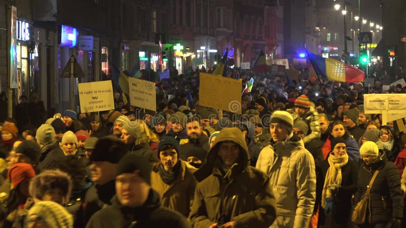 Άνθρωποι που περπατούν στην οδό βραδιού, πλήθη με τις αφίσσες