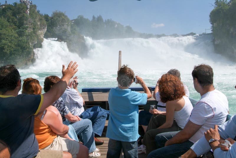 Άνθρωποι σε μια βάρκα τουριστών που πλησιάζει τους καταρράκτες του Ρήνου στοκ φωτογραφίες Άνθρωποι σε μια βάρκα τουριστών που πλησιάζει τους καταρράκτες του Ρήνου στοκ φωτογραφίες