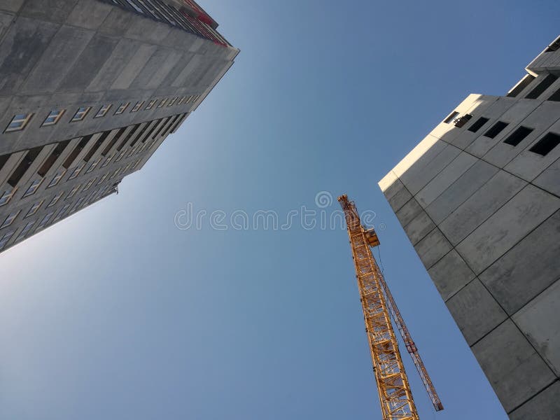 Άνοδοι γερανών οικοδόμησης επάνω από δύο κτήρια Κατώτατο σημείο επάνω στην άποψη σχετικά με το υπόβαθρο μπλε ουρανού στοκ φωτογραφία με δικαίωμα ελεύθερης χρήσης Άνοδοι γερανών οικοδόμησης επάνω από δύο κτήρια Κατώτατο σημείο επάνω στην άποψη σχετικά με το υπόβαθρο μπλε ουρανού στοκ φωτογραφία με δικαίωμα ελεύθερης χρήσης