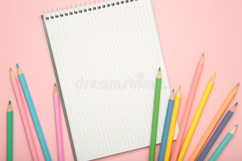 Άνοιγμα σημειωματάριου με πολύχρωμο μολύβι σε ροζ φόντο στοκ φωτογραφίες
