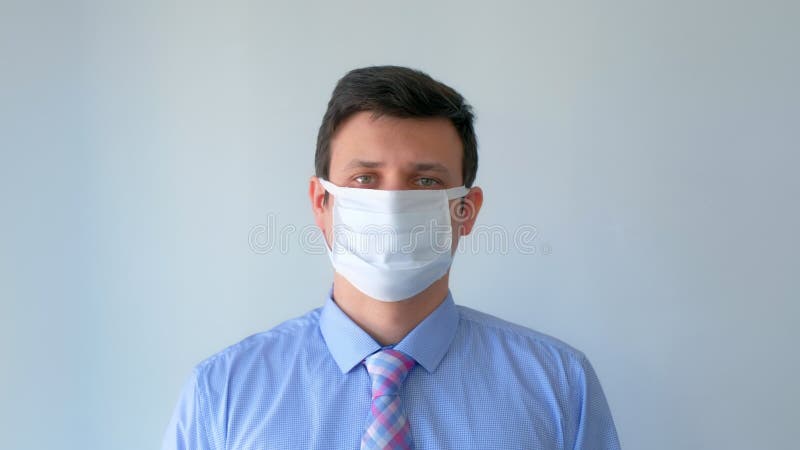 άντρας βάζει προστατευτική ιατρική μάσκα στην πανδημία του κορωναϊρού. φιλμ μικρού μήκους