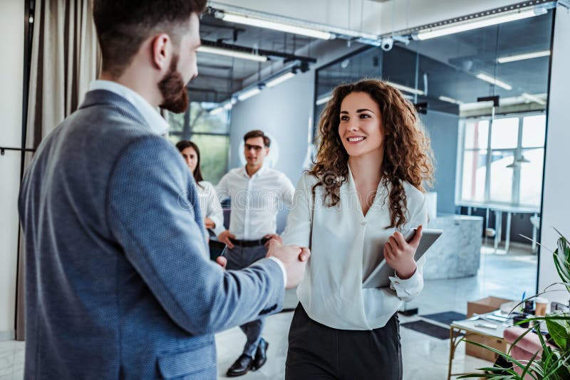 Man and women are shaking hands in office. Collaborative teamwork.Business professionals. Man and women are shaking hands in office. Collaborative teamwork.Business professionals.