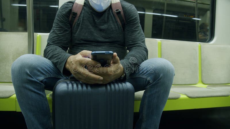 άντρας ταξιδιώτης με βαλίτσα με χρήση τηλεφώνου στο μετρό