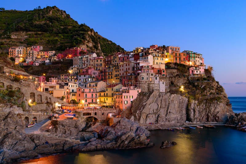 Άποψη ηλιοβασιλέματος και νύχτας Manarola, ένα από τα πέντε μεσογειακά χωριά σε Cinque Terre, Ιταλία στοκ φωτογραφία με δικαίωμα ελεύθερης χρήσης Άποψη ηλιοβασιλέματος και νύχτας Manarola, ένα από τα πέντε μεσογειακά χωριά σε Cinque Terre, Ιταλία στοκ φωτογραφία με δικαίωμα ελεύθερης χρήσης