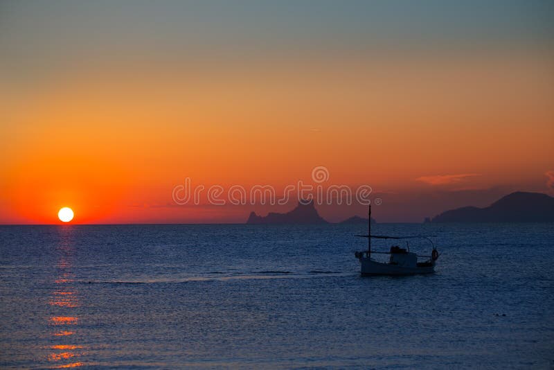 Άποψη και ψαρόβαρκα formentera ES Vedra ηλιοβασιλέματος Ibiza στοκ εικόνα με δικαίωμα ελεύθερης χρήσης
