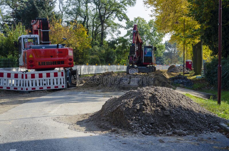 Άποψη κατά μήκος ενός δρόμου diggers σε έναν τόπο του έργου σε μια περιοχή κατοικίας στοκ εικόνες Άποψη κατά μήκος ενός δρόμου diggers σε έναν τόπο του έργου σε μια περιοχή κατοικίας στοκ εικόνες