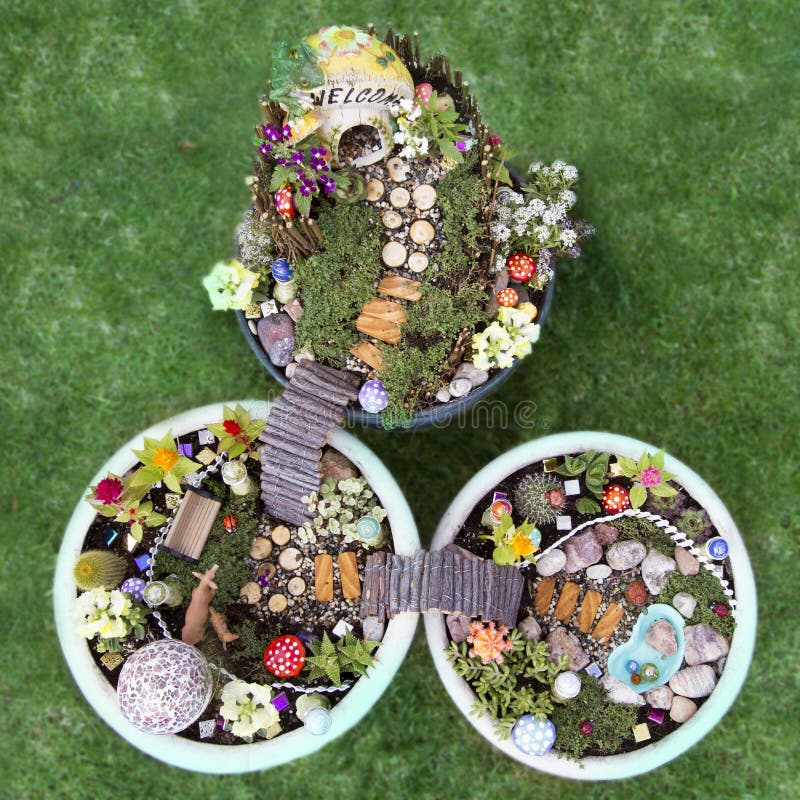 Birds eye view of fairy garden in a flower pot with walking path, wooden bridges and a fairy house. Birds eye view of fairy garden in a flower pot with walking path, wooden bridges and a fairy house.