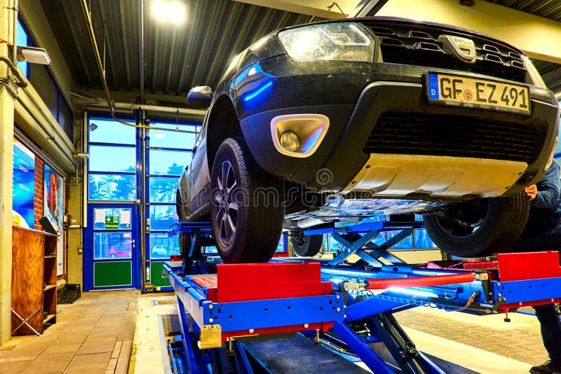 Gifhorn, Germany, December 1., 2020: View of an old car from romanian brand dacia, which was placed on a lifting platform for technical inspection. Gifhorn, Germany, December 1., 2020: View of an old car from romanian brand dacia, which was placed on a lifting platform for technical inspection