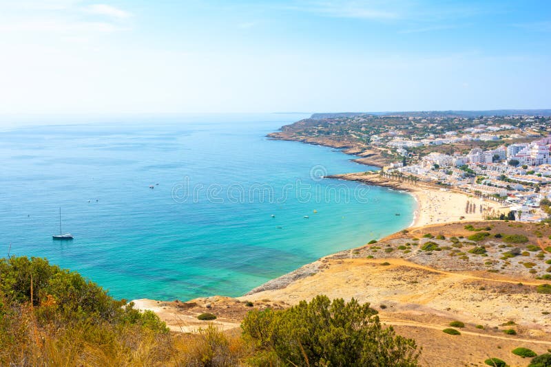Άποψη σχετικά με Praia DA Luz στην ηλιόλουστη ημέρα με τον τυρκουάζ Ατλαντικό Ωκεανό, Αλγκάρβε, Πορτογαλία στοκ εικόνα Άποψη σχετικά με Praia DA Luz στην ηλιόλουστη ημέρα με τον τυρκουάζ Ατλαντικό Ωκεανό, Αλγκάρβε, Πορτογαλία στοκ εικόνα
