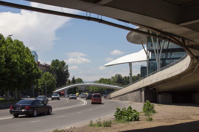 Άποψη της καμπουριασμένης για τους πεζούς γέφυρας κοντά στο σπίτι της δικαιοσύνης στο Tbilisi, Γεωργία στοκ εικόνα Άποψη της καμπουριασμένης για τους πεζούς γέφυρας κοντά στο σπίτι της δικαιοσύνης στο Tbilisi, Γεωργία στοκ εικόνα