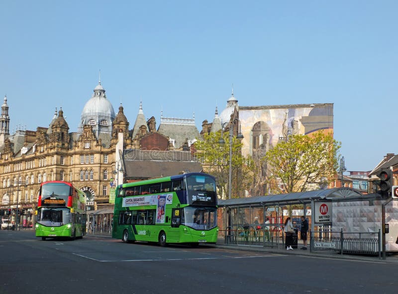 leeds, west yorkshire, england: 17 april 2019: view of new market street with two first buses stopped picking up passengers in leeds city centre. leeds, west yorkshire, england: 17 april 2019: view of new market street with two first buses stopped picking up passengers in leeds city centre