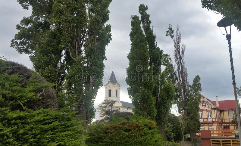 Άποψη του καμπαναριού εκκλησιών και του κτηρίου tudor-ύφους με το διακοσμητικό μισό-εφοδιασμό με ξύλα και evergreens σε Puerto Na στοκ εικόνες Άποψη του καμπαναριού εκκλησιών και του κτηρίου tudor-ύφους με το διακοσμητικό μισό-εφοδιασμό με ξύλα και evergreens σε Puerto Na στοκ εικόνες