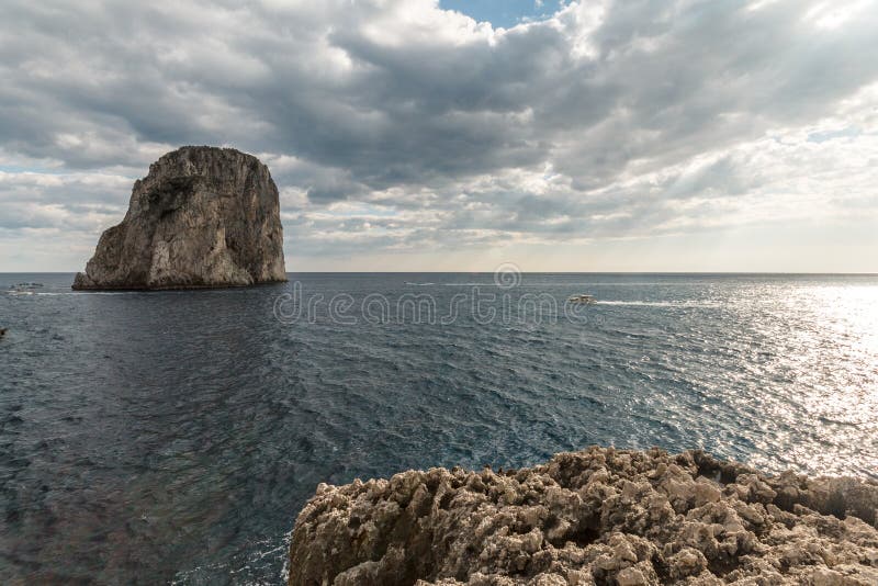 Άποψη του νησιού Ιταλία Capri, με μερικές βάρκες στο νερό κοντά σε Faraglioni στοκ εικόνες Άποψη του νησιού Ιταλία Capri, με μερικές βάρκες στο νερό κοντά σε Faraglioni στοκ εικόνες