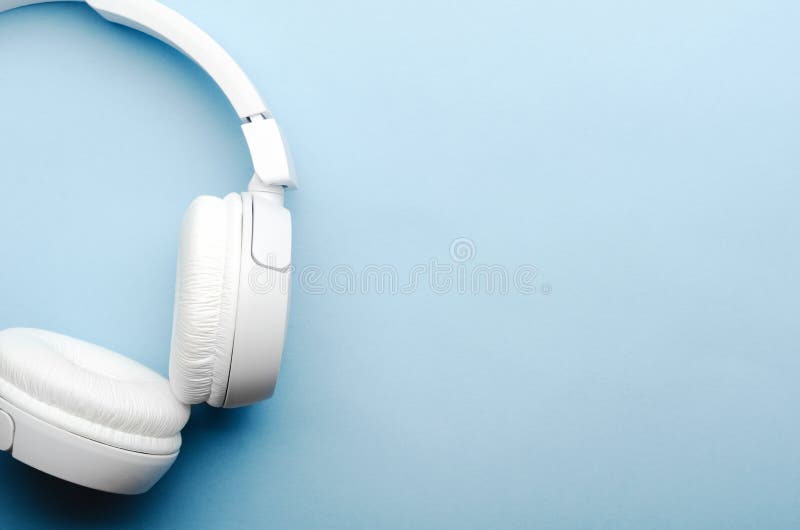 Άσπρα υπερυψωμένα ασύρματα ακουστικά bluetooth σε ένα μπλε υπόβαθρο Κινηματογράφηση σε πρώτο πλάνο, διαστημική, τοπ άποψη αντιγρά στοκ φωτογραφία με δικαίωμα ελεύθερης χρήσης Άσπρα υπερυψωμένα ασύρματα ακουστικά bluetooth σε ένα μπλε υπόβαθρο Κινηματογράφηση σε πρώτο πλάνο, διαστημική, τοπ άποψη αντιγρά στοκ φωτογραφία με δικαίωμα ελεύθερης χρήσης