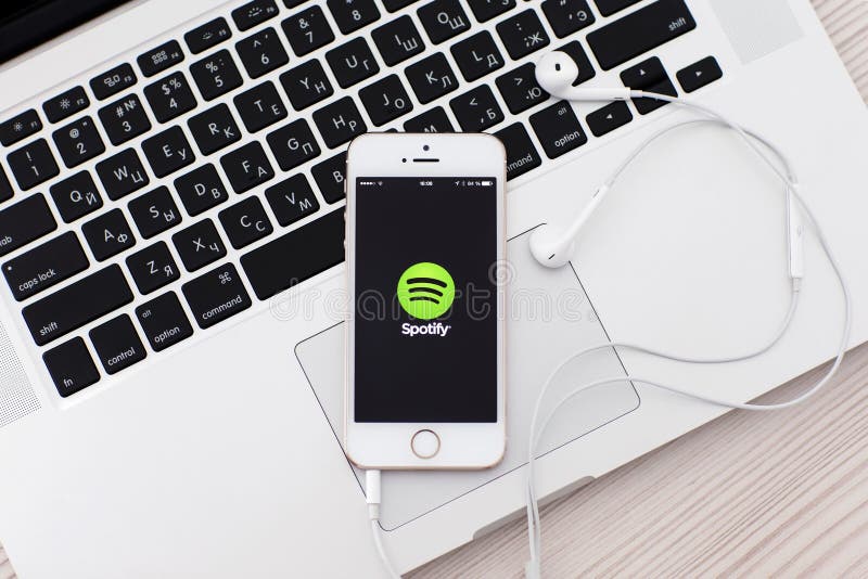 Άσπρο iPhone 5s με την περιοχή Spotify στην οθόνη και τα ακουστικά λ στοκ φωτογραφία με δικαίωμα ελεύθερης χρήσης Άσπρο iPhone 5s με την περιοχή Spotify στην οθόνη και τα ακουστικά λ στοκ φωτογραφία με δικαίωμα ελεύθερης χρήσης