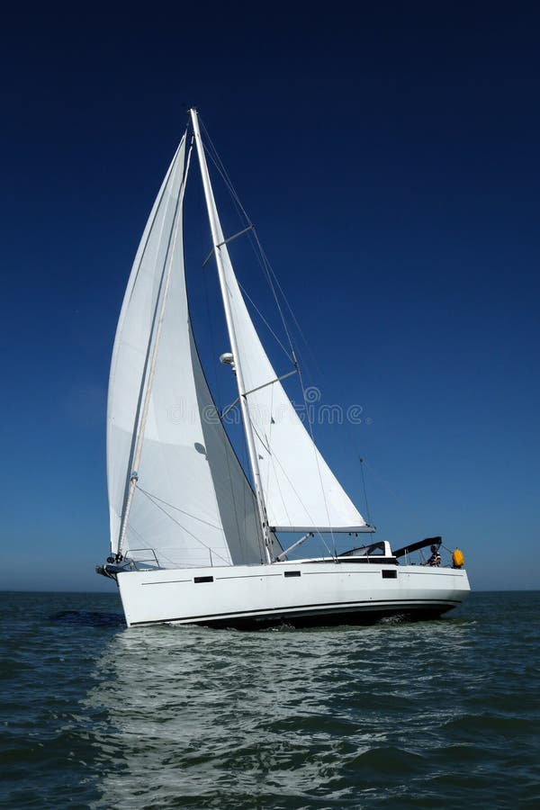 Άσπρο sailboat που παίρνει την ταχύτητα κάτω από το μπλε ουρανό στοκ φωτογραφία με δικαίωμα ελεύθερης χρήσης Άσπρο sailboat που παίρνει την ταχύτητα κάτω από το μπλε ουρανό στοκ φωτογραφία με δικαίωμα ελεύθερης χρήσης