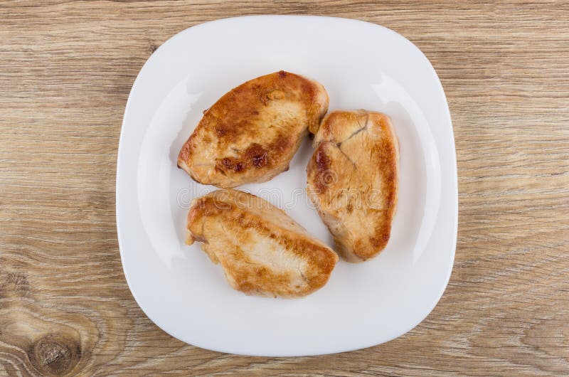 Άσπρο πιάτο με τα κομμάτια του τηγανισμένου κρέατος της Τουρκίας στον πίνακα