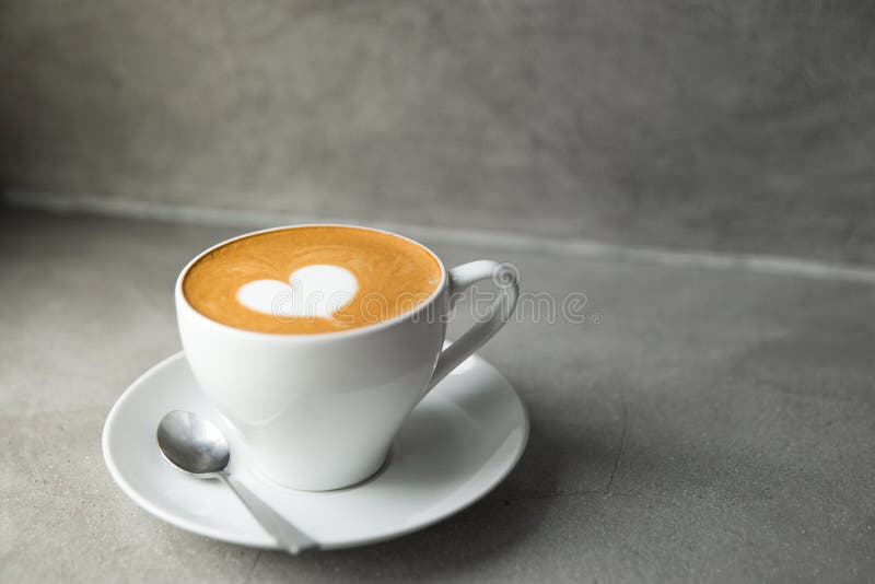 Άσπρο φλυτζάνι του νόστιμου cappuccino με την τέχνη αγάπης latte στοκ φωτογραφία με δικαίωμα ελεύθερης χρήσης Άσπρο φλυτζάνι του νόστιμου cappuccino με την τέχνη αγάπης latte στοκ φωτογραφία με δικαίωμα ελεύθερης χρήσης