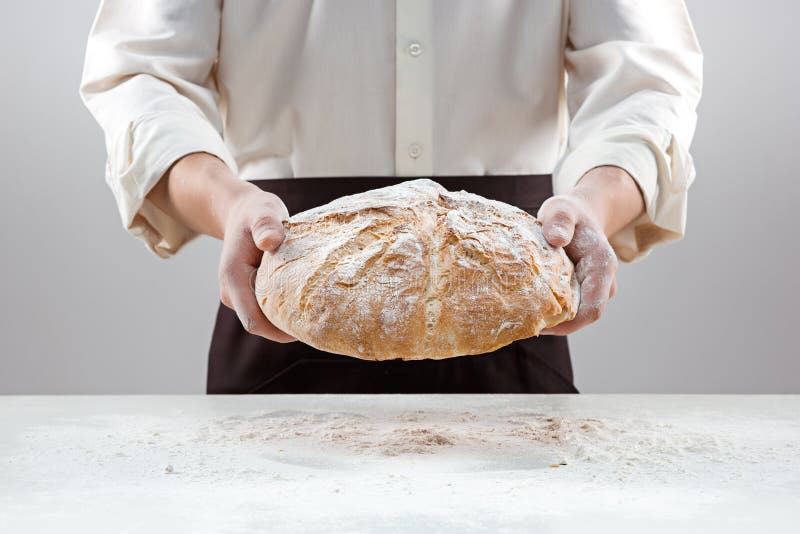 Άτομο Baker που κρατά την αγροτική οργανική φραντζόλα του ψωμιού στα χέρια στοκ φωτογραφία με δικαίωμα ελεύθερης χρήσης