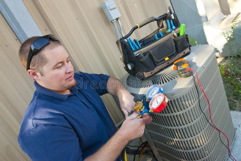 Air Conditioner Repair Man checking levels on commercial air conditioning unit. Air Conditioner Repair Man checking levels on commercial air conditioning unit