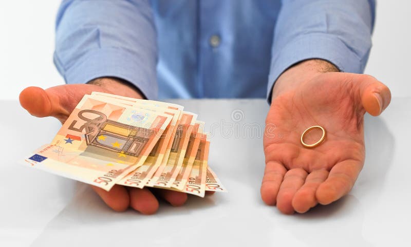 Άτομο με το γαμήλια δαχτυλίδι και τα χρήματα. στοκ εικόνες Άτομο με το γαμήλια δαχτυλίδι και τα χρήματα. στοκ εικόνες